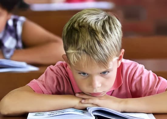 A student struggling at a traditional desk