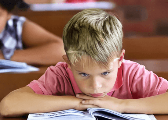 A student struggling at a traditional desk